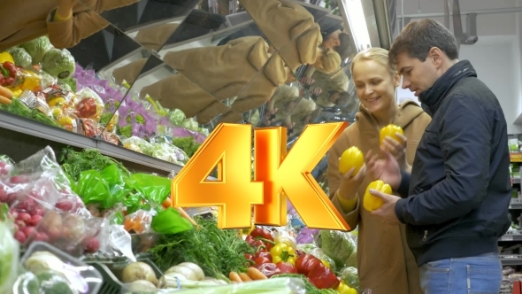 Man And Woman Buying Fresh Vegetables