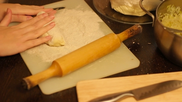 Rolling Out Dough With a Rolling Pin In Hand