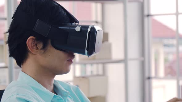 Asian man wearing virtual reality glasses experiencing innovative technology.