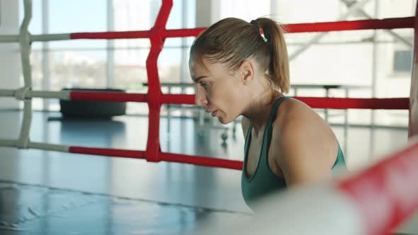 Slow Motion of Tired Sportswoman Resting in Boxing Ring Then Standing Up Ready for Next Fight