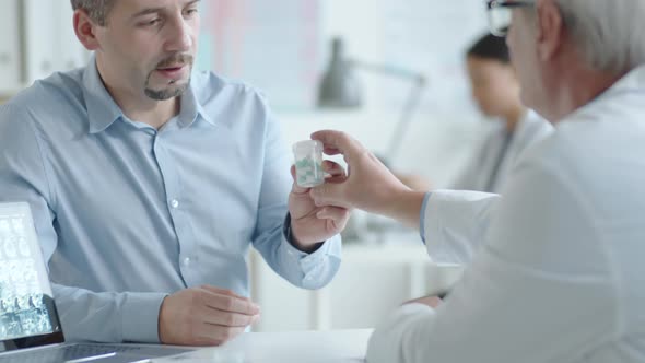 Man Taking Medicine and Shaking Hands with Doctor