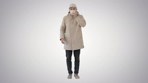 Man in Top Clothes and in Medical Disposable Mask Coughing on Gradient Background
