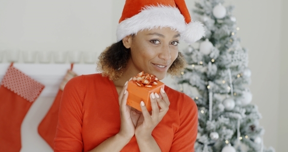 Pretty Woman In Santa Hat Holding a Gift