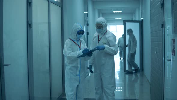 People Work at Clinic, Wearing Protective Suits During Pandemic.