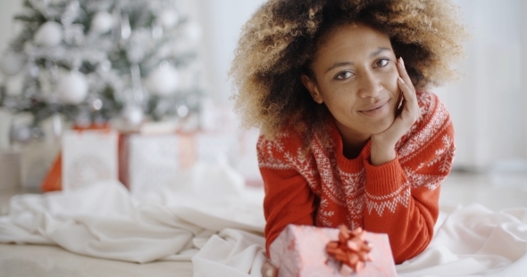 Thoughtful Young Woman With a Christmas Gift