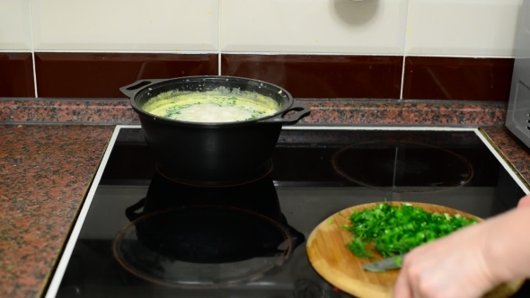 Woman Prepares Cheese Soup In Kitchen