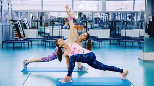 Two Attractive Girls At The Gym Doing Yoga