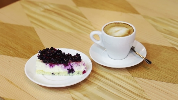 Cup Of Hot Coffee And Cheesecake With Currant On a