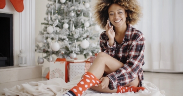 Young Woman Relaxing In Front Of a Christmas Tree