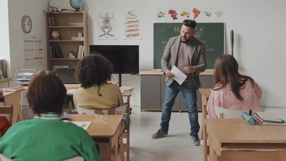 Teacher Giving Test Sheets to Students