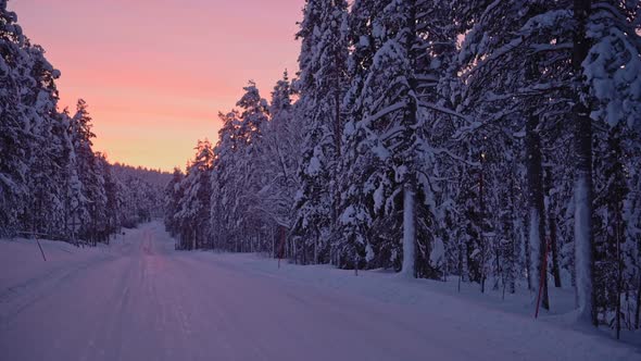The beautiful fiery sunset sky over the snow white landscape of Finland - wide shot