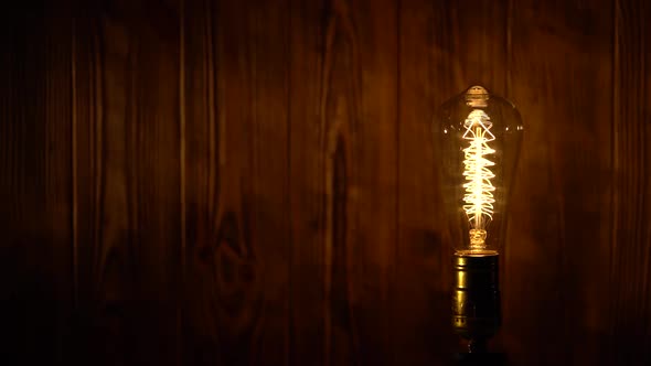 Light Bulb Illuminates on Wooden Background