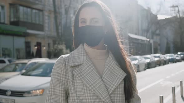 Portrait of a Young Woman with a Black Medical Mask Outdoors