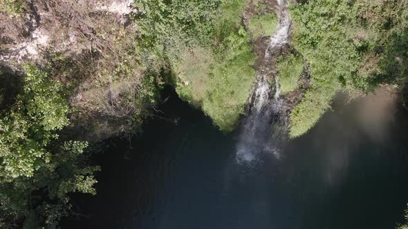 Aerial View of a Hidden Waterfall Lagoon Surrounded by Foliage