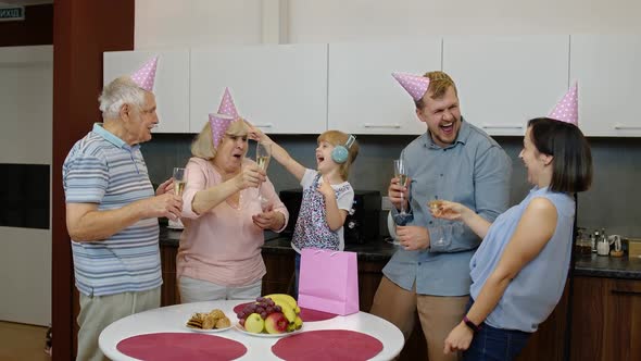 Multigenerational Family Members with Child Girl Kid Celebrating Birthday Party. Drinking Champagne