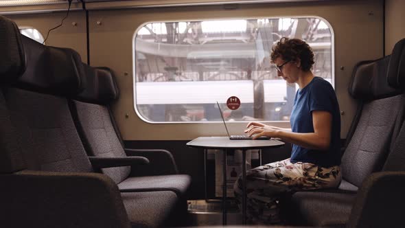 Woman in Glasses Working on a Laptop While Waiting for the Train Departure