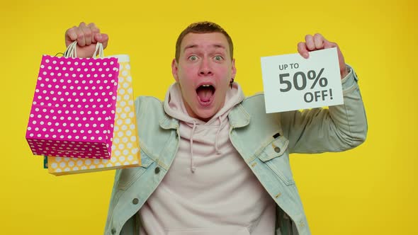 Cheerful Teen Man Showing Shopping Bags and Up To 50 Percent Off Inscriptions Banner Black Friday