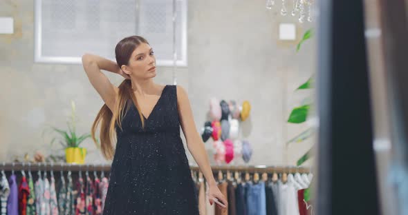 Nice Girl Trying on an Elegant Dress in Front of a Mirror