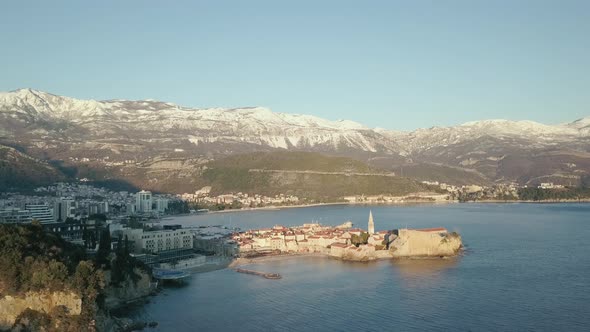 Aerial View of winter Budva, the old town in Montenegro and snow-capped mountains
