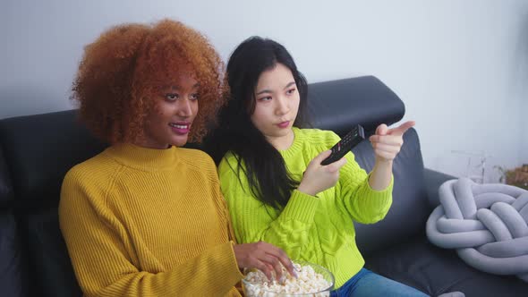 Multiracial Friendship. Afican American Black and Asian Woman Eating Popcorns and Watching Movies