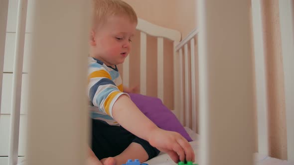 Boy Playing Cars In Crib