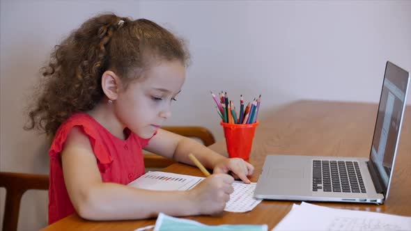 Distance Learning Online Education Schoolgirl Sits at Home at Her Desk Performs a School Assignment