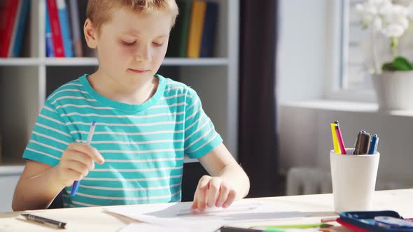 Boy is Doing  Homework at the Table. Cute Child is Learning at Home.