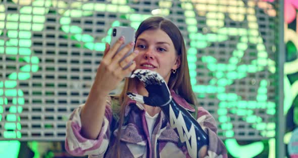 A Beautiful Woman with a Bionic Prosthesis Holds a Smartphone Records a Video Takes an Incoming Call