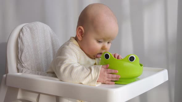 Cute Little Baby Eating In High Chair At Home