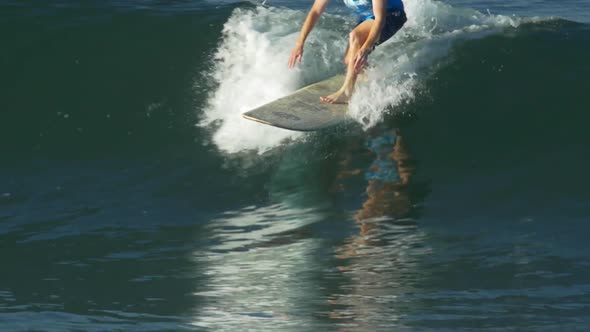 A male surfer rides a wave on a longboard surfboard.