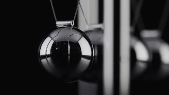 The balls of a Newtons Cradle colliding in slow motion