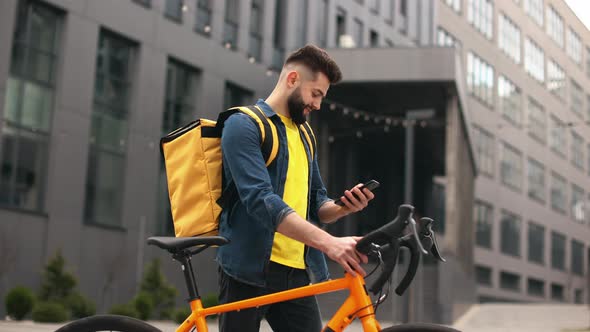 The Food Delivery Guy is Standing and Smiling