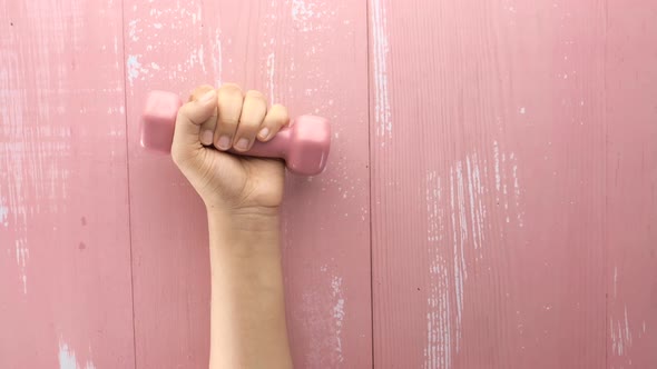 Top View of Woman Hand Holding Pink Dumbbell.