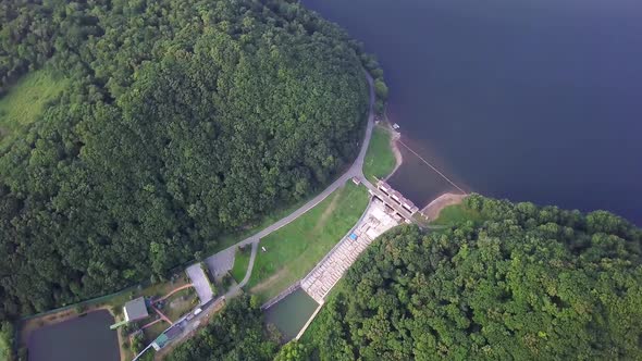 Drone View of Smooth Water and a Dam Surrounded By Green Hills