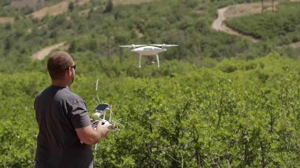 View of man flying drone over green landscape