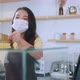 Attractive asian female cafe worker wears face mask and gloves giving takeaway food bag to custome - VideoHive Item for Sale