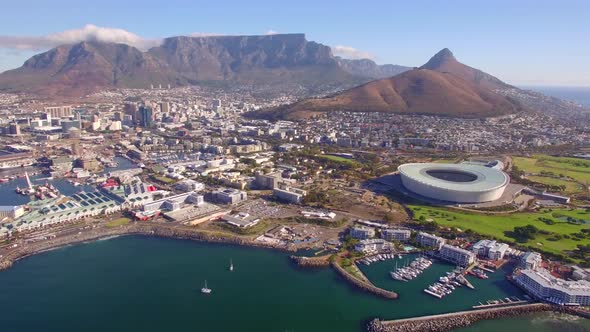 Aerial travel drone view of Cape Town, South Africa with Table Mountain and stadium.