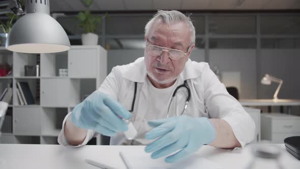 A Grizzled Experienced Public Hospital Doctor in His Office at His Desk