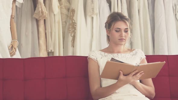 Bride Reading Book or Catalogue in Wedding Studio