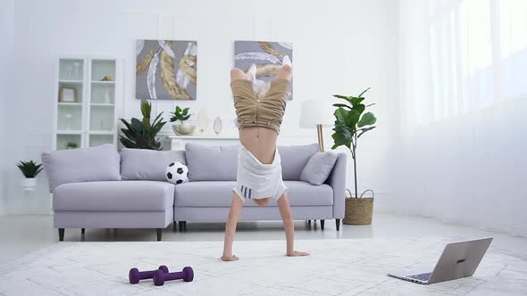 Sportive Confident Teen Boy Doing Handstand on the Carpet, Walking on His Hands