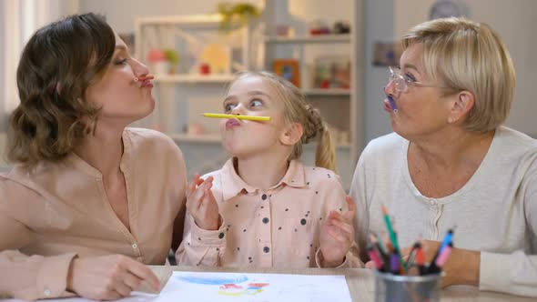 Playful Woman With Daughter and Granddaughter Holding Pencils Like Mustache, Fun