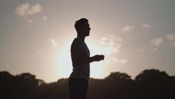 Man Stretchs In Park Before He Works Out