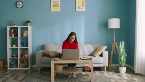 Freelancer Woman Is Working at Laptop at Home