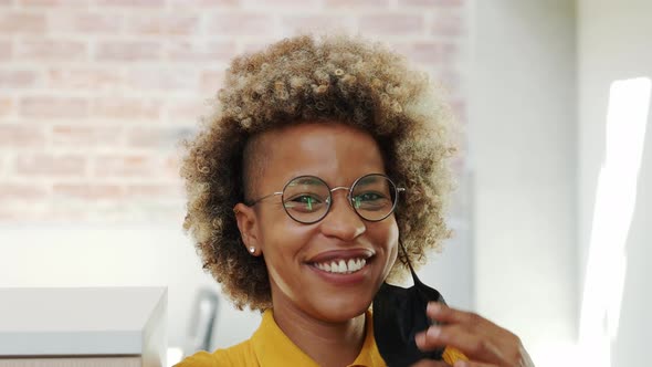 Portrait of Afro Woman Taking Off Medical Mask and Smiling Looking at Camera