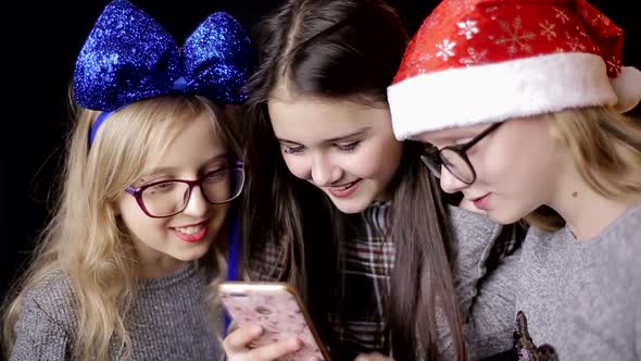 Friendship, technology and internet concept - three smiling teenage girls with smartphones