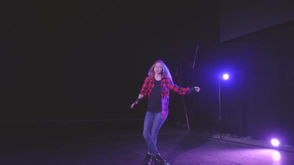 Blonde Roller Girl with Protective Gloves, Gracefully Swirls on Rollerblades on Front Wheels in Dark