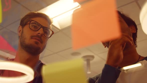 Business colleagues discussing over sticky notes