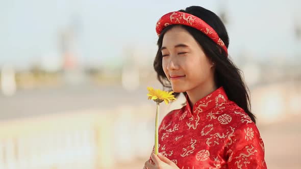 Beautiful Vietnamese Girl in Red Traditional Dress Ao Dai with Yellow Flowers