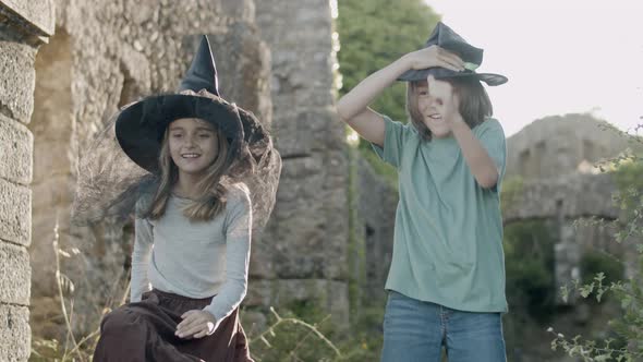 Happy Kids Standing Among Stone Walls of Castle and Dancing