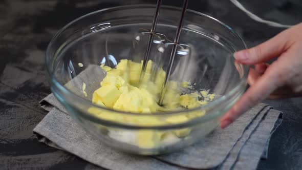 Mixing butter with sugar with the hand mixer